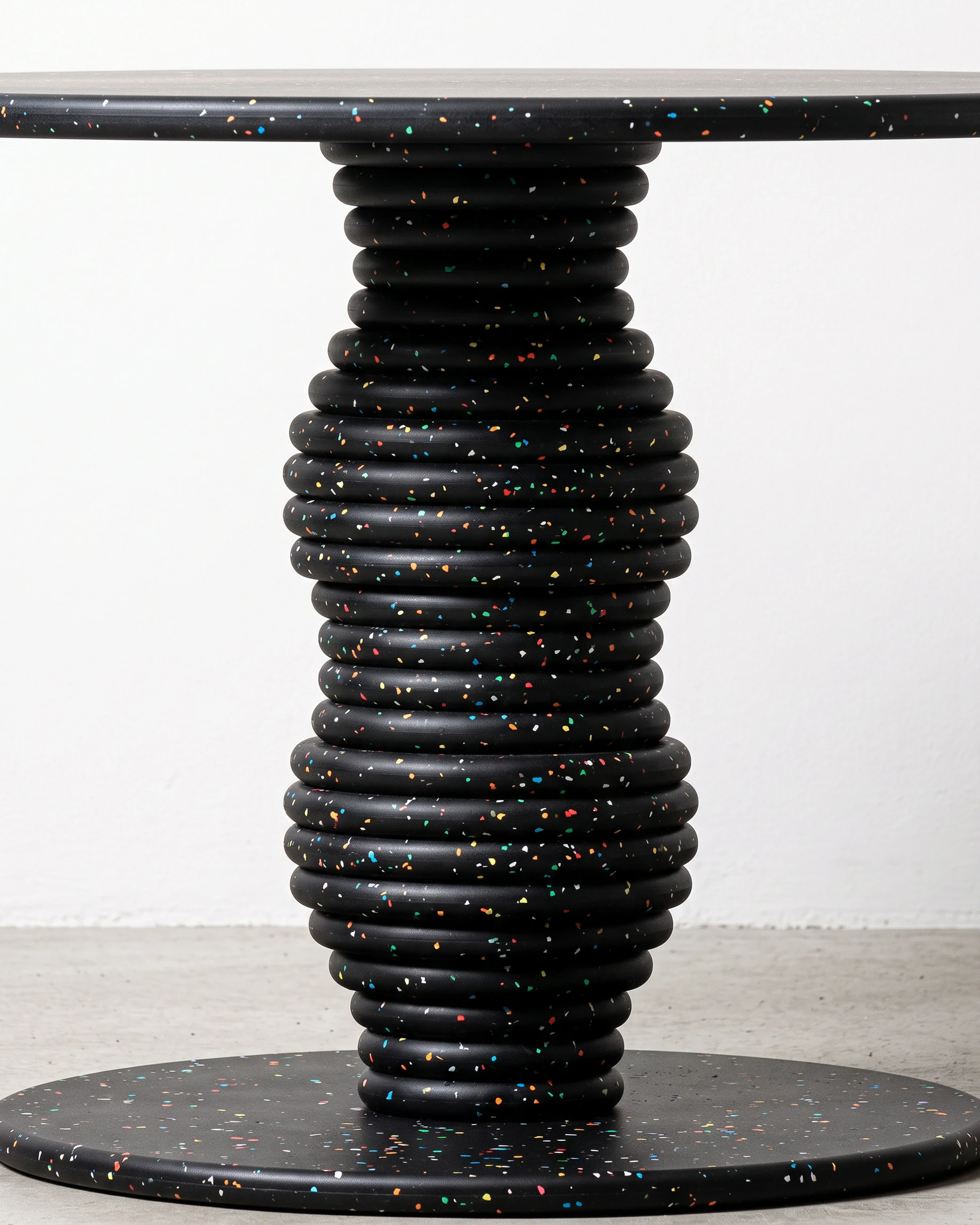 Potter, stacked-disc table Ø80 × 52, black, colour flecks: joint close-up