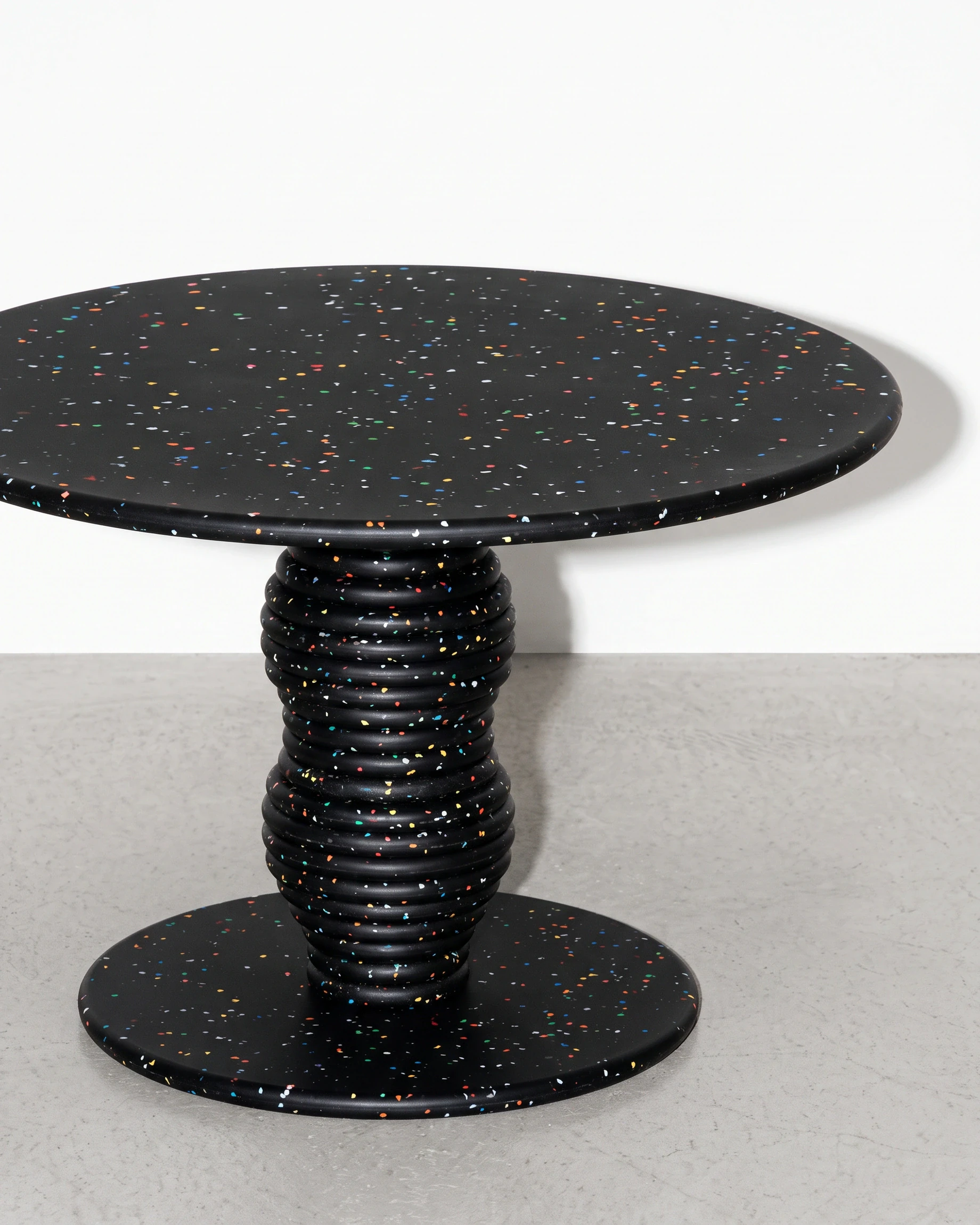 Potter, stacked-disc table Ø80 × 52, black, colour flecks: front right view