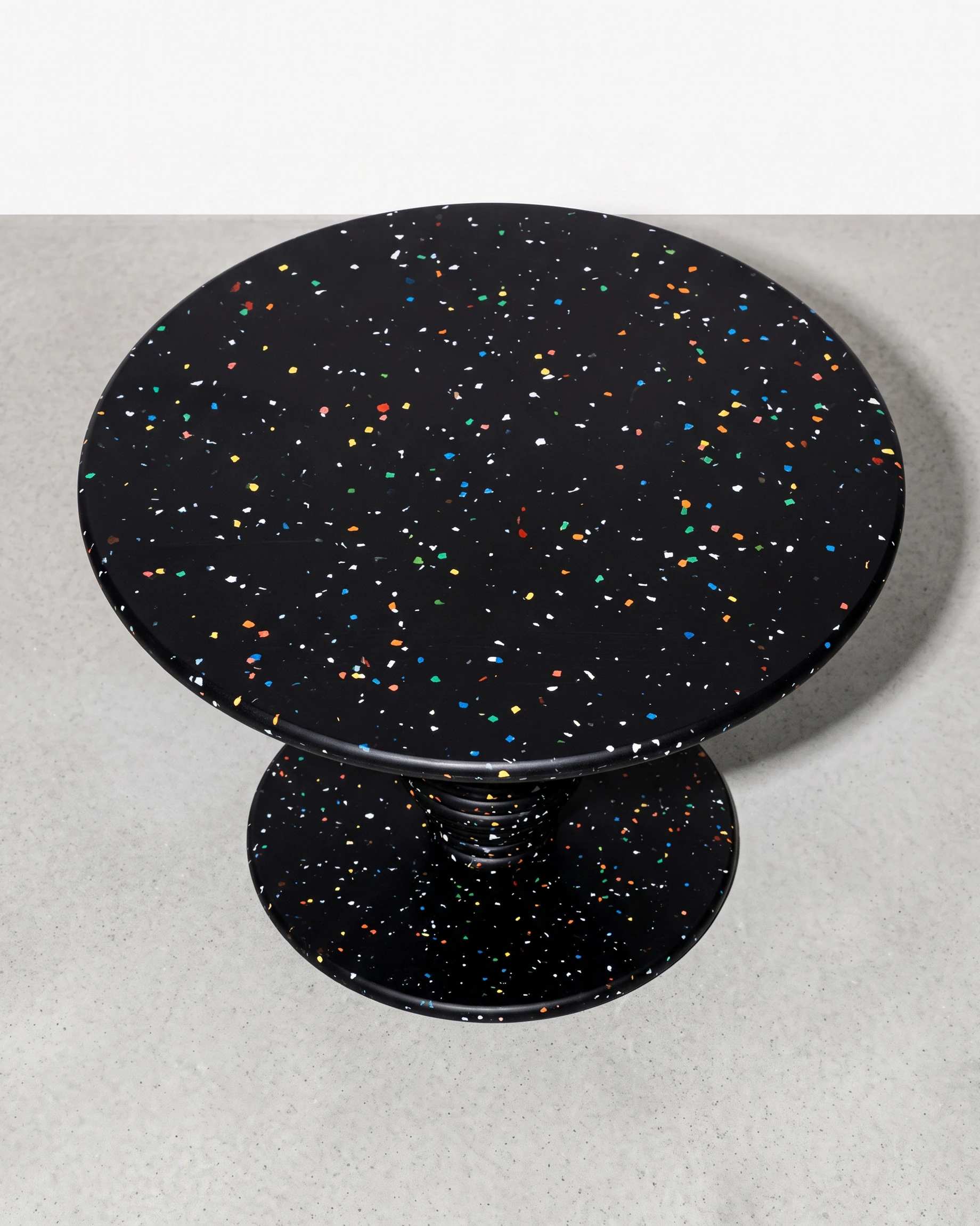 Potter, stacked-disc table Ø80 × 52, black, colour flecks: top view