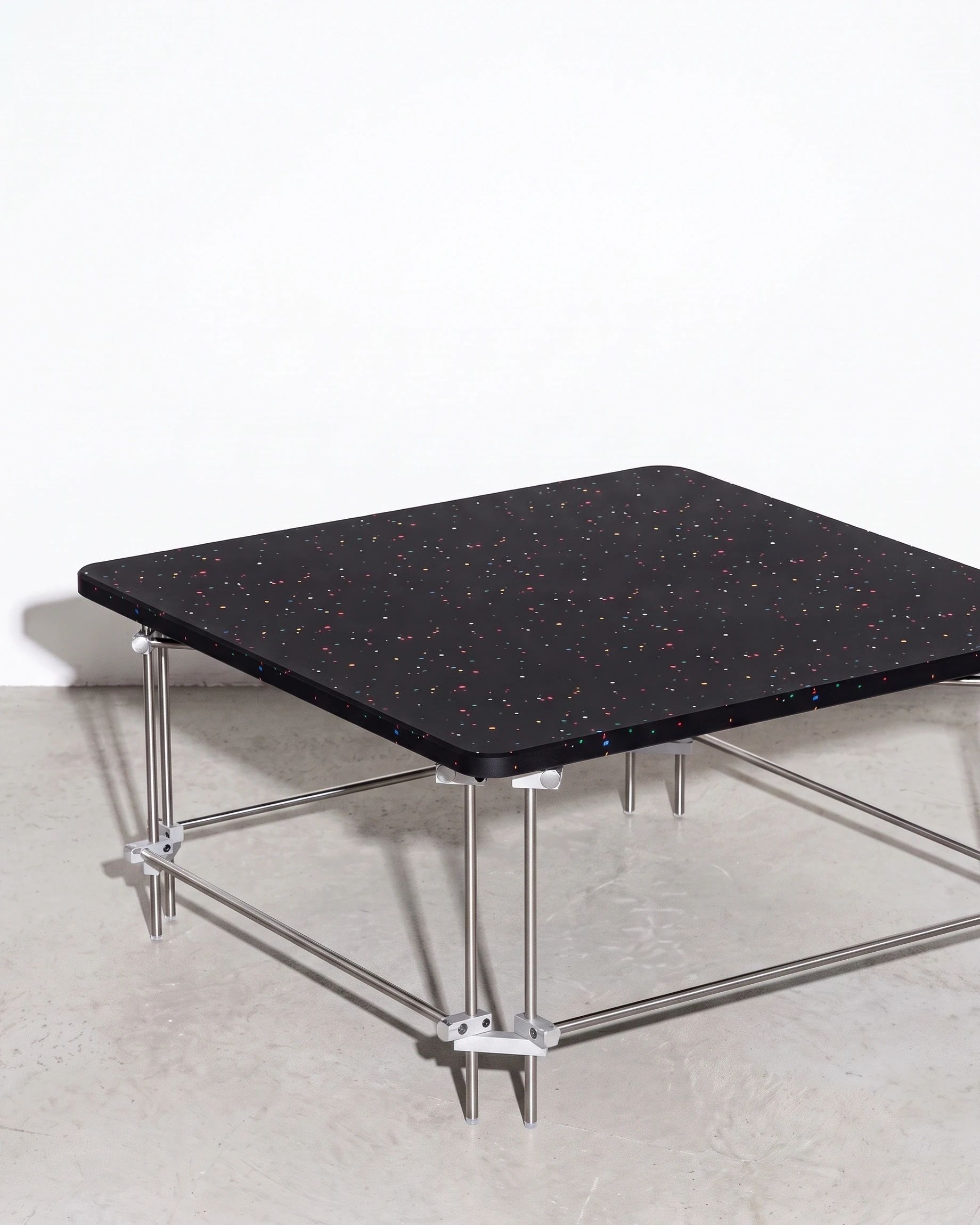 Chess Player, coffee table 80 × 80, black, colour flecks: front left view